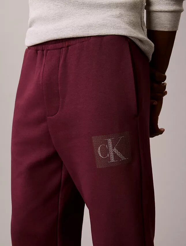 Calças de treino com grafismo Monogram em camadas de velo Calças de treino com grafismo Monogram em camadas de velo