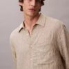 Camisa de botões com corte descontraído, em tecido frisado com riscas tingidas no fio Camisa de botões com corte descontraído, em tecido frisado com riscas tingidas no fio